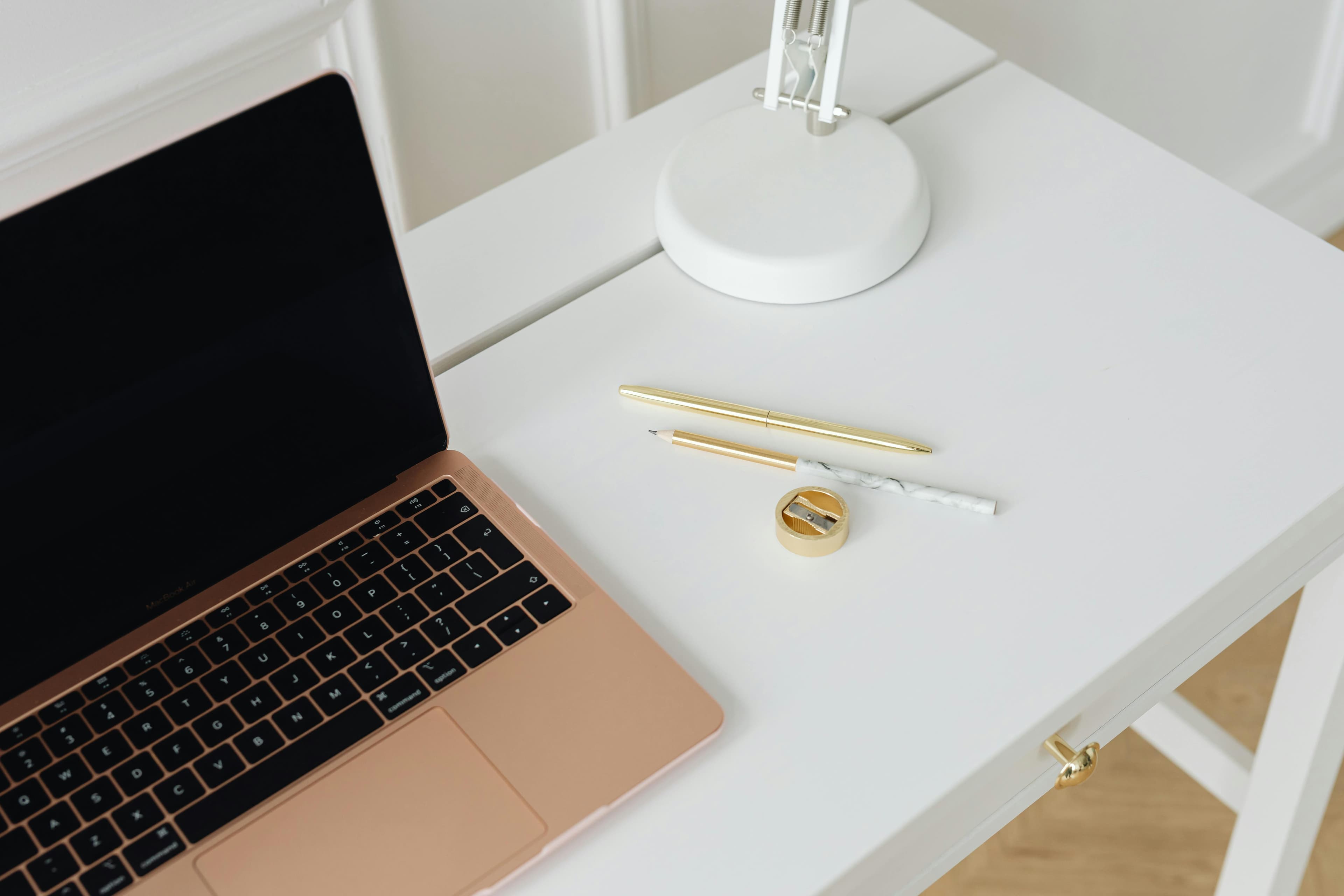 A clean home office desk with a laptop and gold stationery, representing accessible legal tools for BC families
